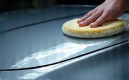 Applying polish to a sedan's hood